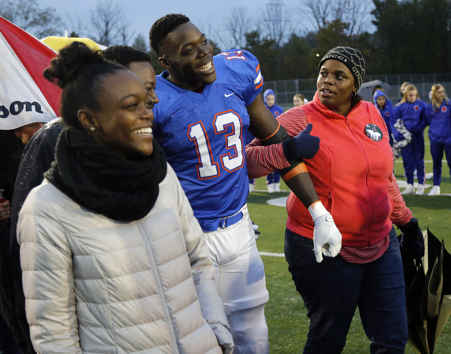 Second Place, Sports Picture Story - Kyle Robertson / The Columbus Dispatch, "Zach Harrison"The Harrison's family Zahara, Jimmie, Zach and Tracey figure out how to hold arms while being introduced for Zach's senior night on October 26, 2018. 