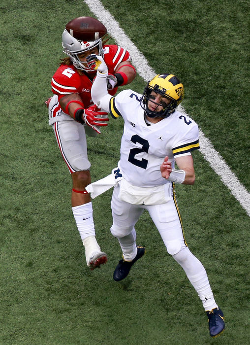 First Place, Team Picture Story - Tyler Schank / The Columbus Dispatch, "Ohio State vs. Michigan"Ohio State defensive end Chase Young (2) attempts to tackle Michigan quarterback Shea Patterson (2) in the second half at Ohio Stadium on Nov. 24, 2018. The pass was intercepted by Ohio State Buckeyes safety Jordan Fuller (4). 