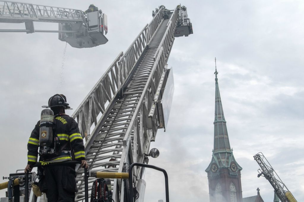 First Place, Chuck Scott Student Photographer of the Year - Gaelen Morse / Ohio UniversityA Southborough firefighter prepares to climb to the top of a ladder truck during an 8-alarm fire at a shopping center in downtown Natick, Mass., on July 22, 2019. It took fire crews from two counties nearly 12 hours to get the blaze under control. No one was seriously hurt during the fire but more than six businesses were lost.
