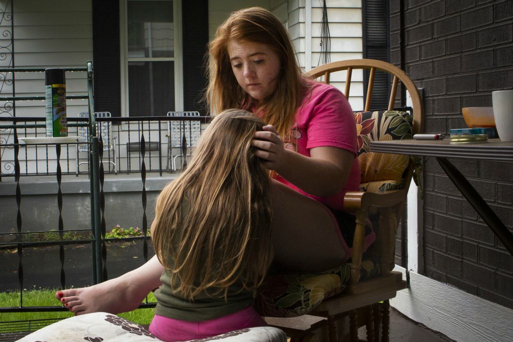 Second Place, Chuck Scott Student Photographer of the Year - Madeleine Hordinski / Ohio UniversityKristie Combs strokes her daughter's hair as she sits on the porch of a home in Norwood on Wednesday, June 19, 2019. Combs is a resident of Bellevue, Kentucky, but she babysits in Norwood, a neighborhood consistently hit with overdoses this summer. She said she has lost probably five members to heroin addiction, and that it often leaves grandparents raising their grandchildren when parents have drug-related issues or lose custody.