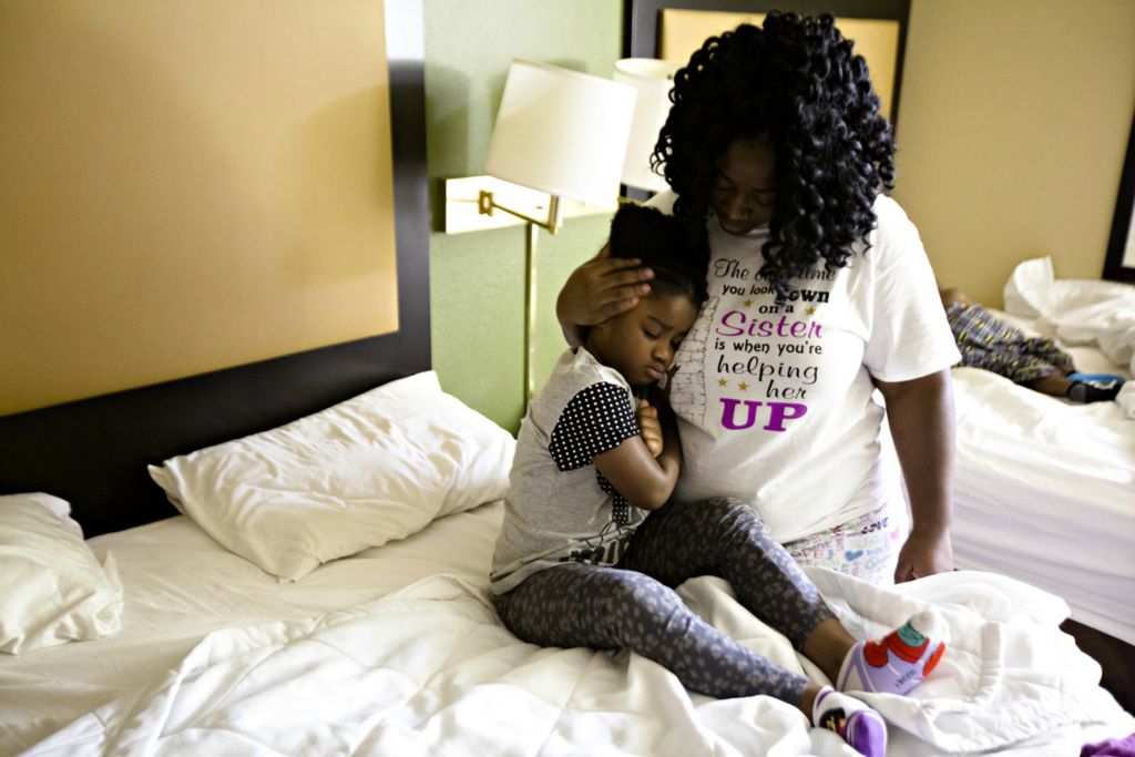 Third Place, Feature Picture Story - Albert Cesare / The Cincinnati Enquirer, “Finding Home”April Austin embraces her daughter Jasmine Austin, 6, as she wakes her up to get her ready for school at the Extended Stay America hotel in Springdale on Sept. 19, 2018. Austin and her four children stayed in the two-bed hotel room for five days while trying to obtain other housing. 