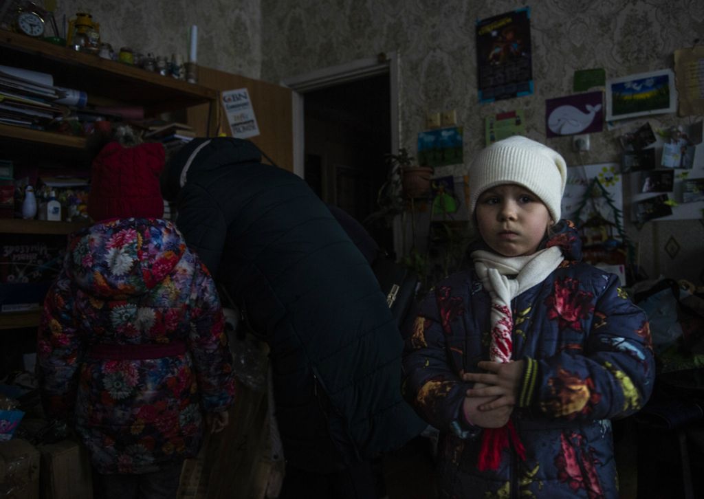 Award of Excellence, Feature Picture Story - Matthew Hatcher / Freelance, “Ukraine's Forgotten War”A young girl listens to the sounds of shelling as her mother and sister riffle through donated clothing and housewares collected by a church group in Zolote, Ukraine on February 27, 2019. The constant shelling and fighting on the frontlines of the Donbas War has had a psychological impact on civilians, especially children who often times spend nights sleeping in basements.Children living on the frontlines of the war have high rates of anxiety and depression, associated with the constant stress of what has become daily life.