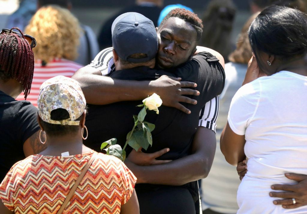 First Place, News Picture Story - Kurt Steiss / The Blade, “Dayton Shooting”Summary: In the early hours of Aug. 4, 2019, a 24-year-old gunman opened fire on an entertainment district in Dayton, Ohio, killing nine only 13 hours after a mass shooting took place in El Paso, Texas, killing 22. Dayton came together in the following hours and days to heal in the face of tragedy. Dayton resident Donna Johnson, front, whose nephew Thomas McNichols was killed in the shooting, receives a hug from Caleb White, also from Dayton, back, during a vigil at Levitt Pavilion Dayton in Dayton, Ohio, on Sunday, Aug. 4, 2019. The afternoon vigil was held after a mass shooting took place overnight in the Oregon District.