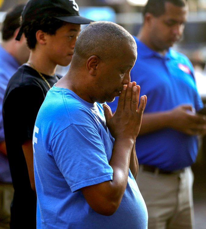 First Place, News Picture Story - Kurt Steiss / The Blade, “Dayton Shooting”Basim Blunt, from Yellow Springs, Ohio, prays near wreathes set up for each of the victims of the mass shooting before an evening vigil held in the Oregon District in Dayton, Ohio, on Sunday, Aug. 4, 2019. 