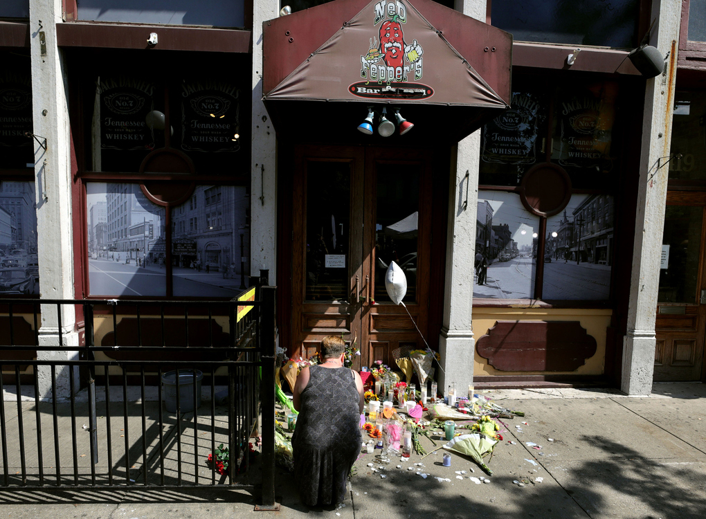 First Place, News Picture Story - Kurt Steiss / The Blade, “Dayton Shooting”A woman, who did not want to be identified, pays her respect at a makeshift memorial outside Ned Peppers at the Oregon District in Dayton, Ohio, on Monday, Aug. 5, 2019. 