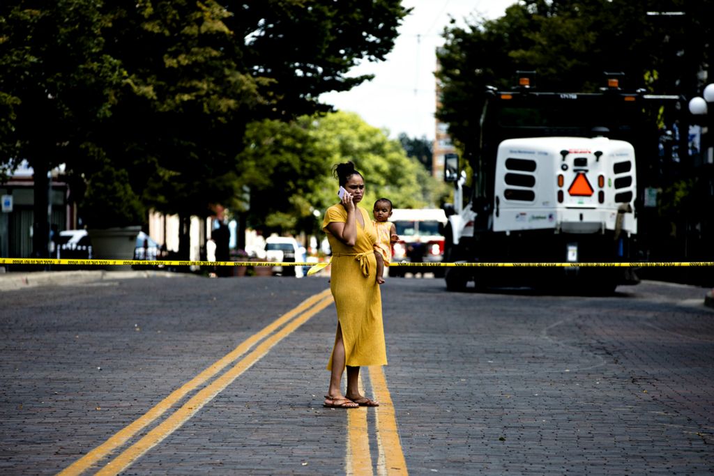 Award of Excellence, News Picture Story - Albert Cesare / The Cincinnati Enquirer, “Mass Shooting Dayton ”A woman holding a baby stands outside the Oregon District crime scene the 400 block of E. Fifth Street, Sunday, Aug. 4, 2019, in Dayton , Ohio. Ten people where killed, including the gunman, and 26 injured in a mass shooting at the crime scene. 