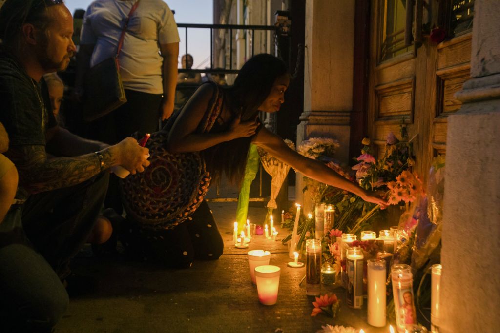 Award of Excellence, News Picture Story - Albert Cesare / The Cincinnati Enquirer, “Mass Shooting Dayton ”Allison Carter lays flowers at the foot of the door outside Ned Pepper's Bar during a vigil held for the victims of  a mass shooting on the street, the 400 block of East 5th Street, where it happened in the Oregon District of Dayton, Ohio, on Sunday, Aug. 4, 2019. 