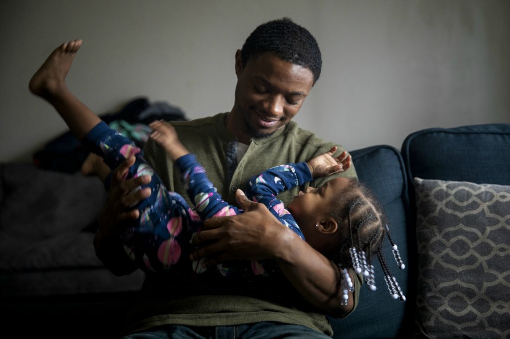 First Place, Photographer of the Year - Large Market - Meg Vogel / The Cincinnati EnquirerMarine Corps veteran LeRon Davis holds his daughter Ahnalia, 2, in their apartment in Mt. Airy on Thursday, November 21, 2019. Davis, 30, is now six months sober. He is working at Saint Vincent de Paul but says that it's not enough. Davis is trying to find a better way to support his family of six. He dreams of creating a better life for his children. 