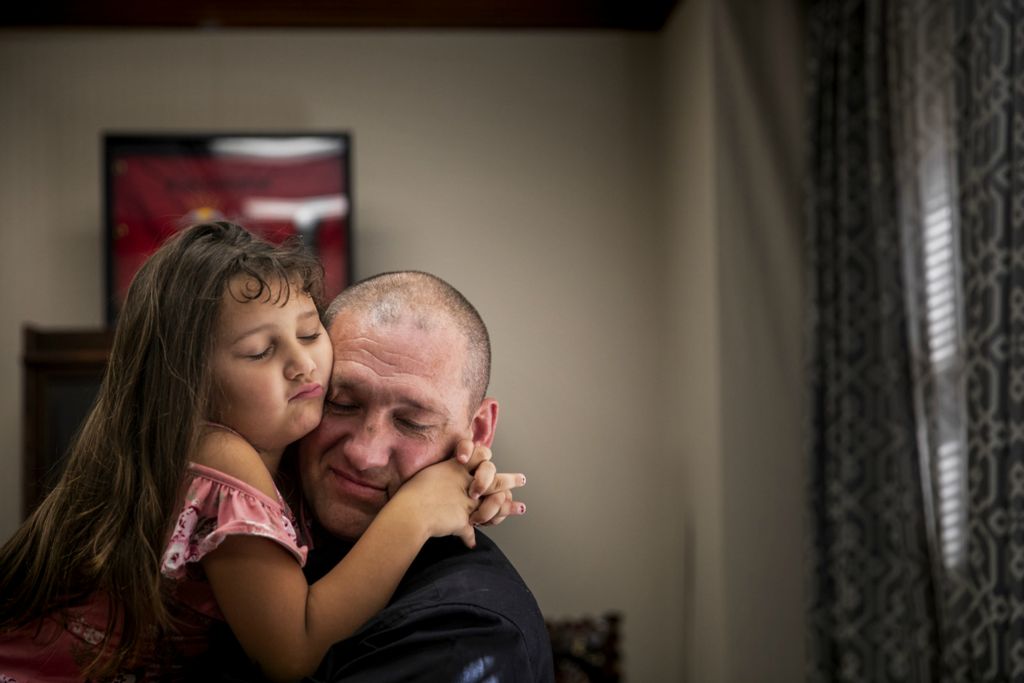 First Place, Photographer of the Year - Large Market - Meg Vogel / The Cincinnati EnquirerCaity, 5, embraces her step-grandpa Michael McQueen as she waits to be adopted with her brother Carter, 9, on National Adoption Day at the Hamilton County Probate Court in downtown Cincinnati on Friday, November 1, 2019. McQueen picked out Caity's pink dress for the special day with Caity's approval. He also did her hair, like he does every morning. McQueen has even created a concoction to work out the tangles of her long brown hair. McQueen has been the caregiver for the children for more than five years. Their biological mom struggles with drug addiction. 