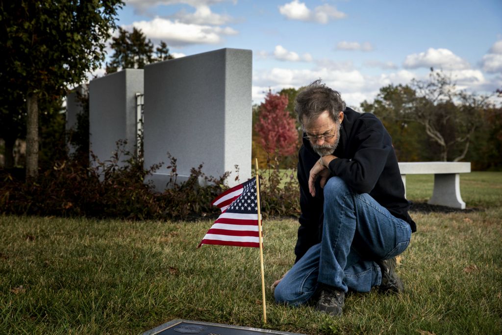 First Place, Photographer of the Year - Large Market - Meg Vogel / The Cincinnati EnquirerHoward Berry, 63, kneels at a veteran's grave at Gates of Heaven Cemetery in Montgomery on Tuesday, October 22, 2019. Berry's son is buried nearby. Joshua A. Berry killed himself in 2013, several years after he was injured in a shooting at a military base in Texas. He was 36. Josh suffered from post-traumatic stress disorder, and Howard says his son felt left behind by the military. He has been trying to raise awareness about veteran suicide ever since.