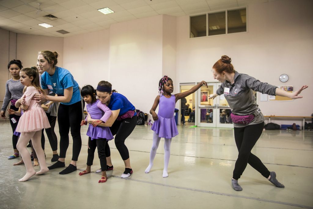 First Place, Photographer of the Year - Large Market - Meg Vogel / The Cincinnati EnquirerCincinnati Children’s Hospital physical therapist volunteers Ellen Wisner, Molly Gamble, Alexis Froehlke and Jackie Sidow help Ella Williams, Saanvi Kopta and Marteisha Thomas make their final bows at the end of class at the Cincinnati Ballet on Saturday, February 2, 2019. 