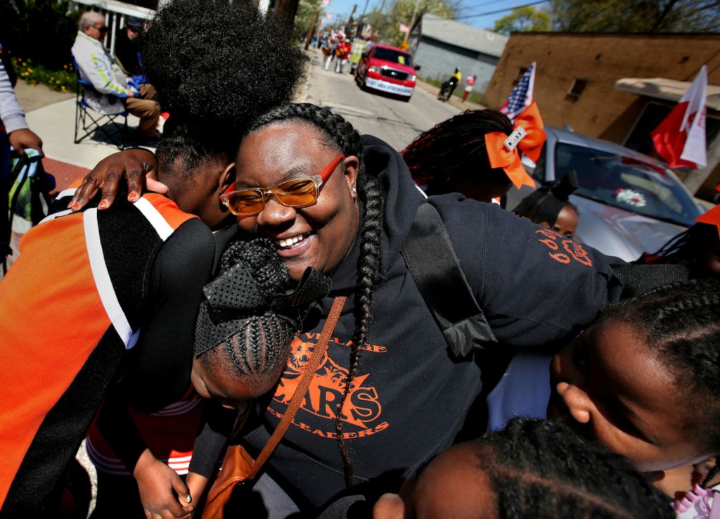 Second Place, Photographer of the Year - Large Market - Lisa DeJong / The Plain DealerMayia Allen, 37, hugs her Slavic Village Bears Cheerleaders after they completed their final dance routine at the end of the Slavic Village Constitution Parade. Allen says every cheerleader is like her daughter and is determined to be a bright spot for young girls in this poverty-stricken neighborhood. Allen is the coordinator and founder of the popular cheerleading group which has won national competitions.