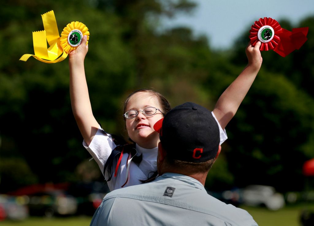 Second Place, Photographer of the Year - Large Market - Lisa DeJong / The Plain DealerAlessandra Kimble, 13, of North Ridgeville, basks in pure joy as she celebrates her second and third place sportsmanship ribbons with her father Shawn Kimble at the Chagrin Hunter Jumper Classic Riders with Disabilities Competition at the Cleveland Metroparks Polo Field. Kimble won second place in the Beginner Walk Only - Trail category and third place for the Beginner Equitation category. Kimble has been riding horses for six years. Sponsored by the Fieldstone Farm Therapeutic Riding Center since 1992, riders with disabilities are given the opportunity to demonstrate their sportsmanship abilities on horseback at the show. The Fieldstone Farm Therapeutic Riding Center offers equine programs for people with a wide range of disabilities, from cognitive impairments such as Down Syndrome or autism, to Cerebral Palsy and spinal cord injuries. 