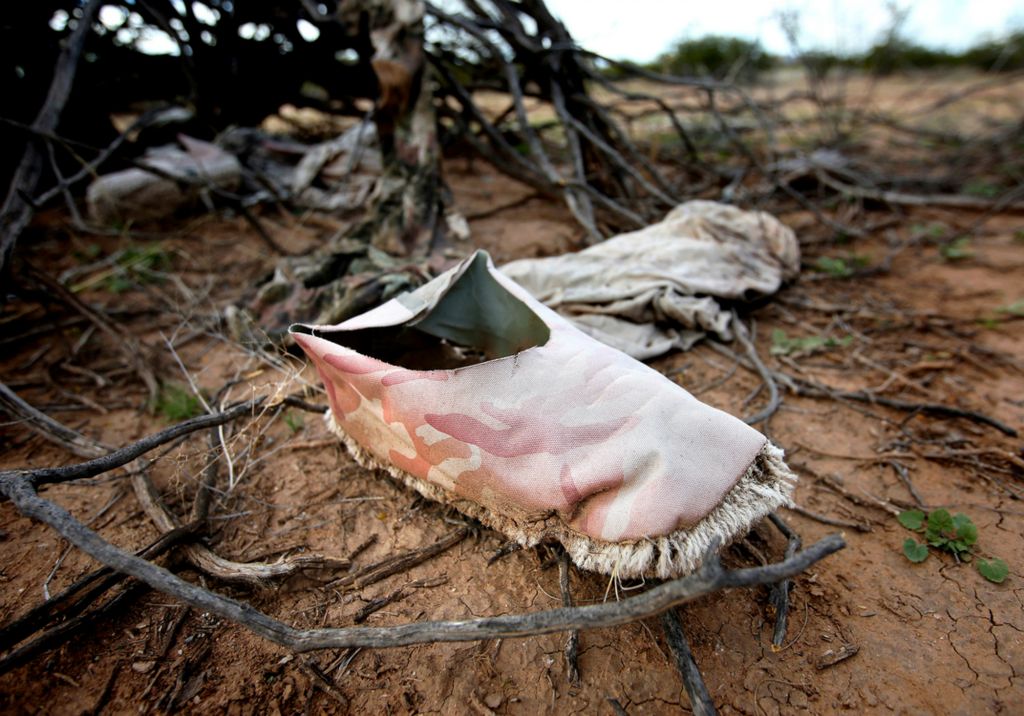 Second Place, Photographer of the Year - Large Market - Lisa DeJong / The Plain DealerHomemade shoes with carpet sewn into the soles - which make it harder to trace footprints in the desert - are left behind by drug smugglers in this heavily traveled corridor off of South Fuller Road near Three Points, a town southwest of Tucson, Arizona. “The carpet shoes do not leave footprints, the black water jugs do not reflect light, the burlap sacks are specifically designed for marijuana and the clothing is gray-green to blend into the landscape,” said Pima County Sheriff Deputy James Allerton, Public Information Officer. “This was an area where the smugglers waited for their contacts,” he said. “Drug smugglers use the same paths as people entering the country illegally.” 