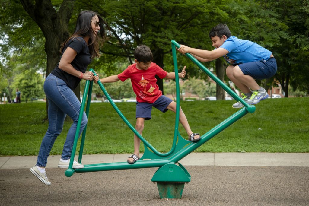 Third Place, Photographer of the Year - Large Market - Joshua A. Bickel / The Columbus DispatchMaria Marionitis, left, of Powell, tries to balance on a stand-up seesaw while playing with her sons, Vasili, 7, center, and  Niko, 10, right, on Wednesday, June 12, 2019 at Goodale Park  in Columbus, Ohio. Marionitis brought her sister, who is visiting from Denver, downtown for the day with her sons and they decided to stop off at the park for the afternoon.