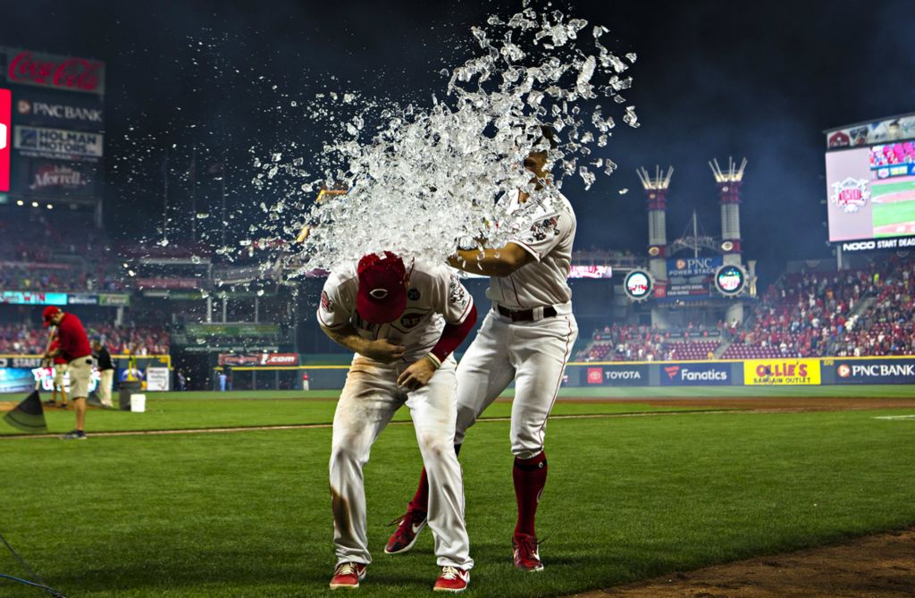 Award of Excellence, Photographer of the Year - Large Market - Albert Cesare / The Cincinnati EnquirerCincinnati Reds left fielder Josh VanMeter (17) is dunked by Cincinnati Reds center fielder Nick Senzel (15) after the MLB game between Cincinnati Reds and St. Louis Cardinals on Saturday, July 20, 2019, in Cincinnati. Cincinnati Reds left fielder Josh VanMeter (17) 2-run home run gave the Reds a two run lead in the seventh inning. 