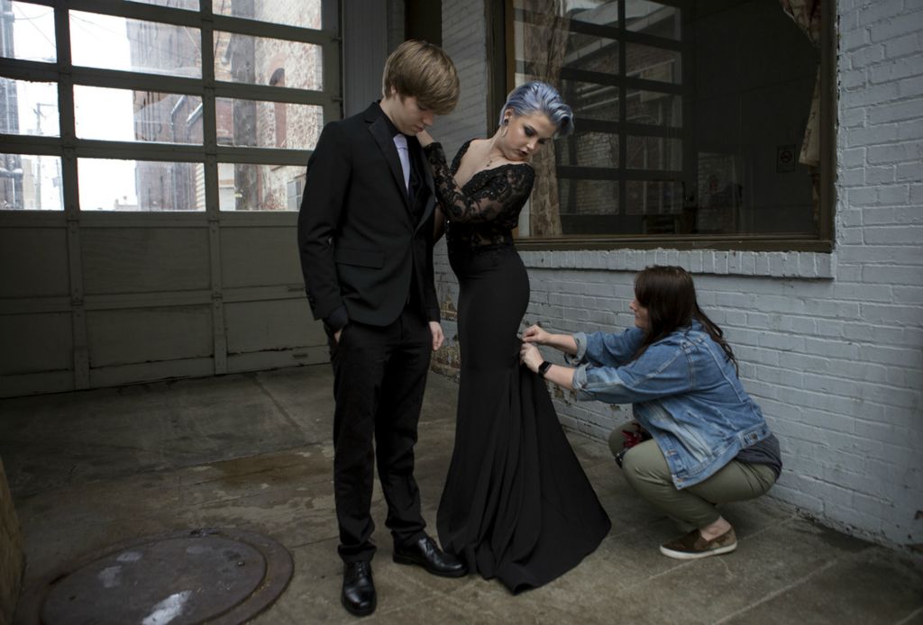 First place, Photographer of the Year - Small Market - Jessica Phelps / Newark AdvocateJazmin and her boyfriend Preston Hanshew pose for pictures before prom in May, 2019. Her mom's friend, Misty McClelland, fixes her dress before snapping the photos. Jazmin's moms' friends have made sure to be at all of Jazmin's homecomings and proms and big events to see her off since her mom's death almost two years ago. While Jazmin appreciates them being there, she also wishes her mom could see her as well.