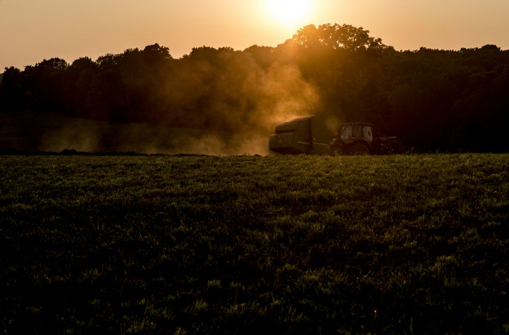 First place, Photographer of the Year - Small Market - Jessica Phelps / Newark AdvocateAndy Hollenback works into the late summer evening, July 13, 2018, bailing hay as the sun sets over Utica where he and his family live and farm. This year there were hay shortages bumping the price up for farmers selling. This extra bit of income helped offset losses from the falling price of soy beans due to the trade war with China.