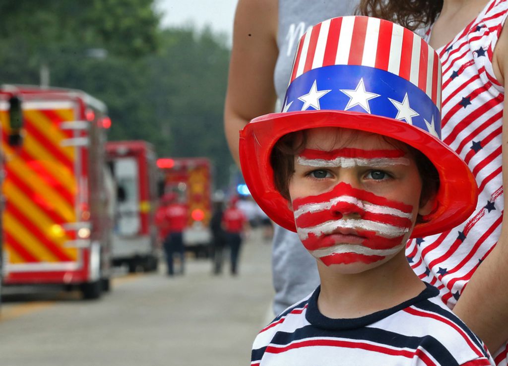 Second Place, Photographer of the Year - Small Market - Bill Lackey / Springfield News-SunCorbin Buehler shows his patriotic spirit as he waits patiently along Enon-Xenia Road for more candy to be thrown his way during the annual Enon Fourth of July Parade Thursday. 