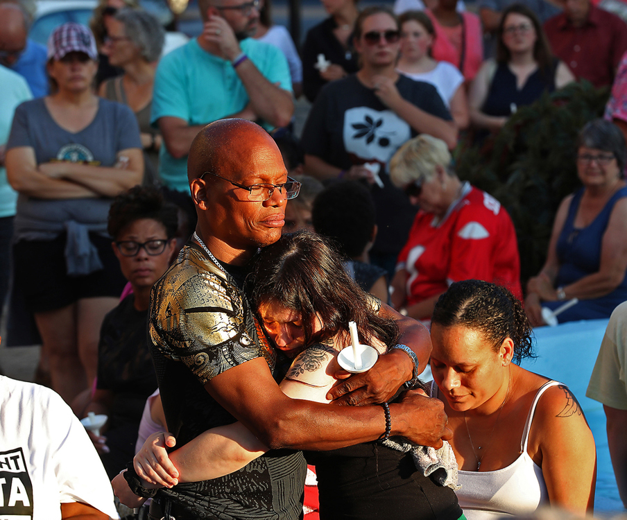 Second Place, Photographer of the Year - Small Market - Bill Lackey / Springfield News-SunRoderick Fudge, the brother of Derrick Fudge, is hugged by a young girl Monday during a candlelight vigil in downtown Springfield for the victims of the Oregon District Shooting. Derrick, who was from Springfield, was one of the nine people killed in the mass shooting. 