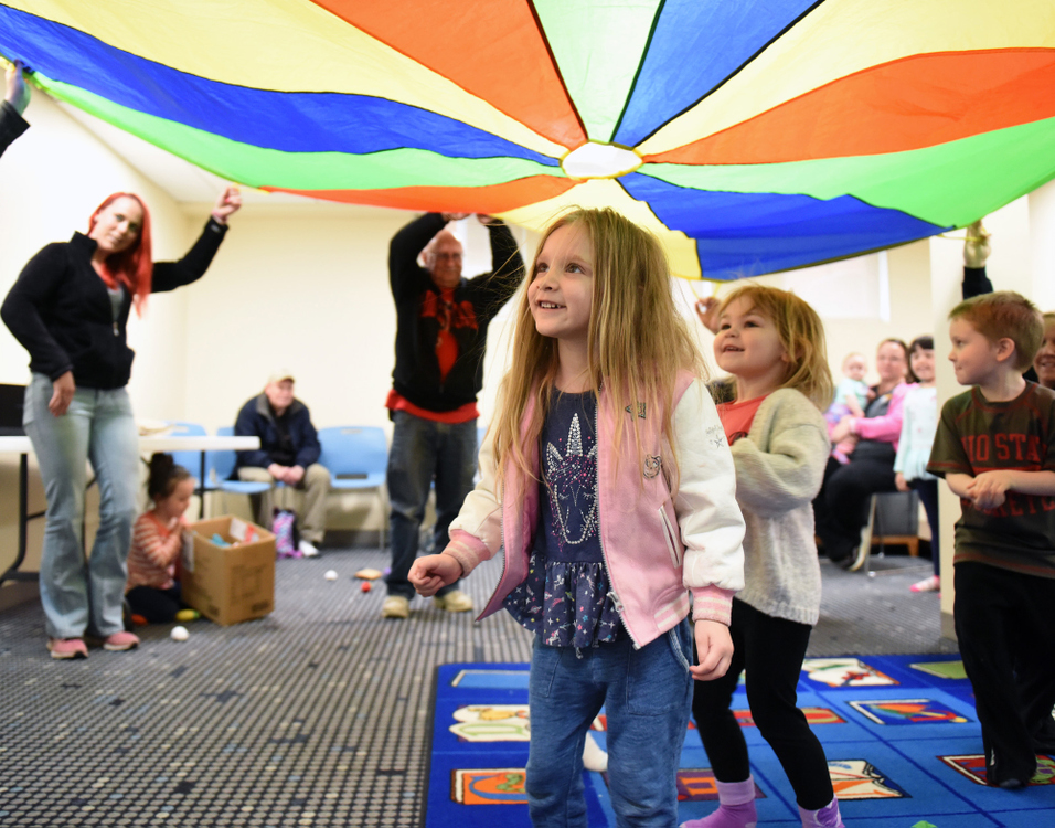 Third Place, Photographer of the Year - Small Market - Erin Caldwell / Sandusky RegisterMilah, 3, walks under the parachute with other children as adults hold it up during parachute playtime at the Bellevue Public Library on  April 30, 2019.