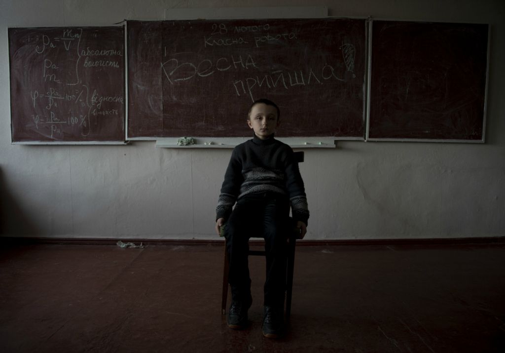 Award of Excellence, Portrait Personality - Matthew Hatcher / Freelance, “Kikita”Kikita, a 4th year primary school student, poses for a portrait in one of the unused classrooms at the school in Troit'ske, Ukraine on February 28, 2019. Troit'ske is a village in the Donbass region of Ukraine on the frontlines of the Donbas War. Frequent shelling and sporadic firefights around the village often keep students from socializing and attending school. Studies have shown that children living in villages on the frontlines of the war have a high rate of psychological disorders such as anxiety and depression.