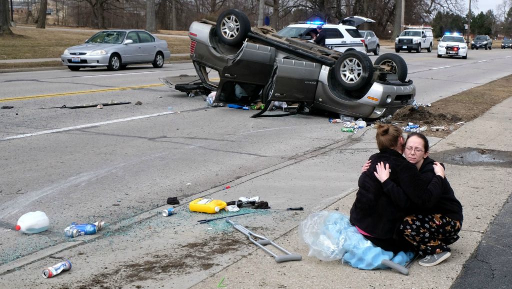Second Place, Spot News - Lori King / The Blade, “Rollover”Ginger Bunting hugs her niece Madison Burleson, 15, after the vehicle Burleson was a passenger in was hit by another car and rolled several times on S. Detroit Ave. in Toledo on March 16, 2019. 