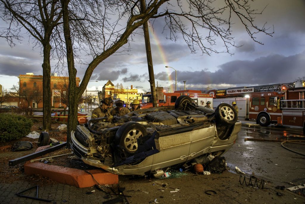 Award of Excellence, Spot News - Andy Morrison / The Blade, “Over the Rainbow”A pair of rainbows, one stronger than the other, reach down from the sky as Toledo Fire and Rescue workers look over the scene of a one vehicle crash in the 200 block of Main Street, December 30, 2019.