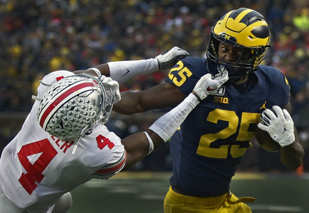 First Place, Ron Kuntz Sports Photographer of the Year - Kyle Robertson / The Columbus DispatchMichigan Wolverines running back Hassan Haskins (25) fights off Ohio State Buckeyes safety Jordan Fuller (4) to score a two-point conversion during the 4th quarter of their game at Michigan Stadium in Ann Arbor, Michigan on November 30, 2019. 