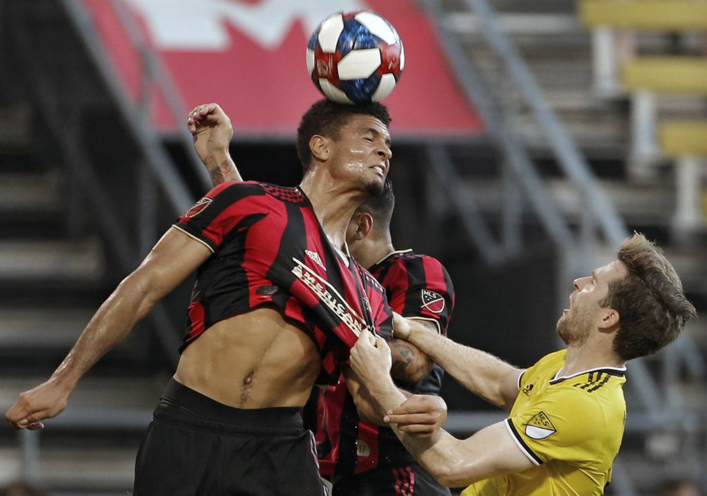 First Place, Ron Kuntz Sports Photographer of the Year - Kyle Robertson / The Columbus DispatchColumbus Crew SC forward Patrick Mullins (32) pulls the shirt of Atlanta United defender Miles Robinson (12) on a header during the first half during an U.S. Open Cup game at MAPFRE Stadium in Columbus, Ohio on June 18, 2019.
