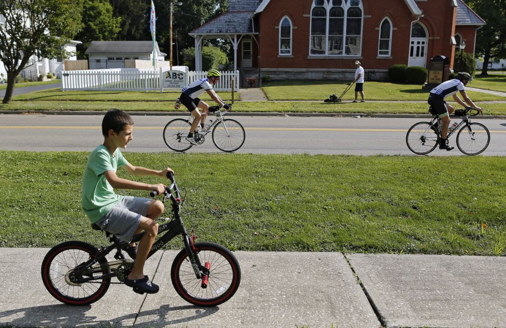 First Place, Ron Kuntz Sports Photographer of the Year - Kyle Robertson / The Columbus DispatchGannon Copper, 9, rides along the sidewalk as riders head down the street during the 11th Pelotonia in Alexandria, Ohio on August 3, 2019.  