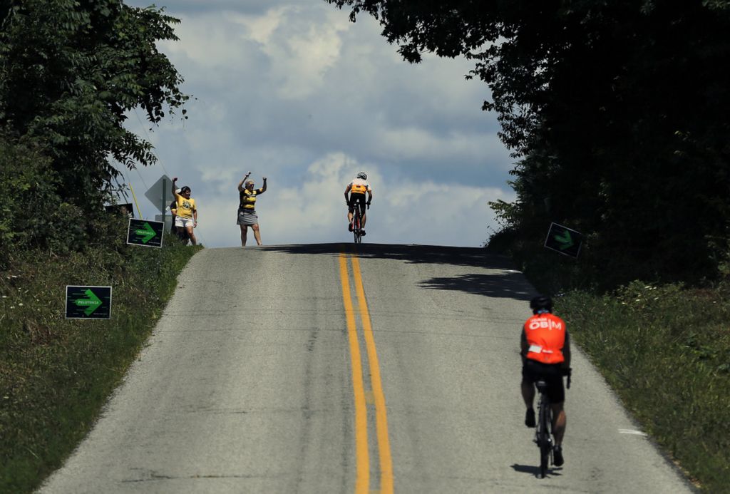 First Place, Ron Kuntz Sports Photographer of the Year - Kyle Robertson / The Columbus DispatchVolunteer Maryann McGrath cheers on riders as they make it up Reynolds hill during the 100 mile route during the 11th Pelotonia on August 3, 2019. 