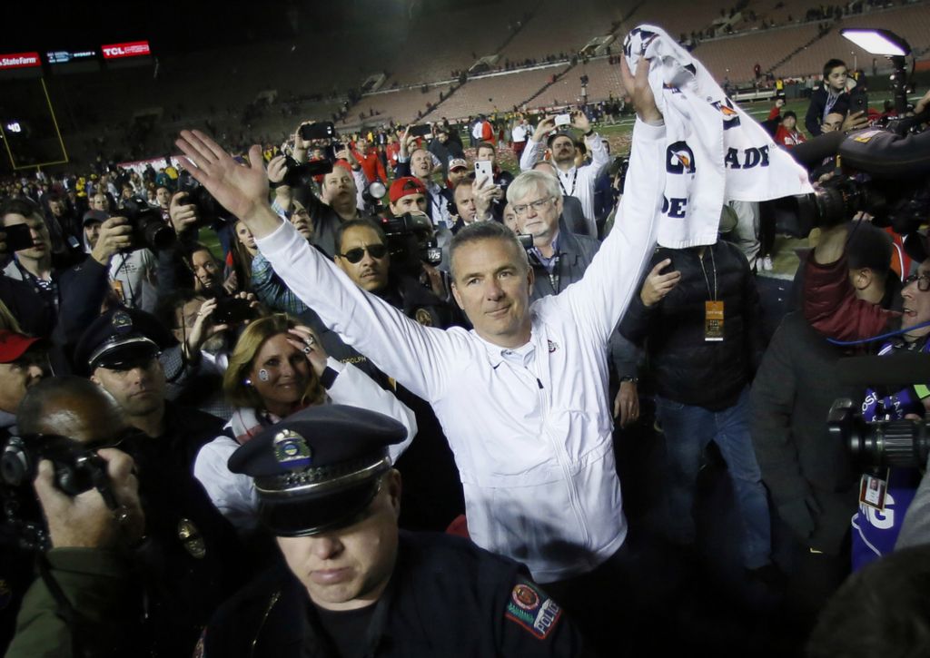 Third Place, Ron Kuntz Sports Photographer of the Year - Adam Cairns / The Columbus DispatchIn his final game as the Ohio State Buckeyes head coach, Urban Meyer salutes the fans with his wife, Shelley at his side, as he leaves the field following the 28-23 win over the Washington Huskies in the Rose Bowl in Pasadena, Calif. on Jan. 1, 2019. 