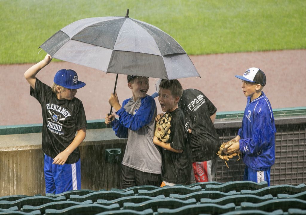 Third Place, Ron Kuntz Sports Photographer of the Year - Adam Cairns / The Columbus DispatchMembers of the Olentangy Stix U10 baseball team, from left, Brayden Mead, Ty Walburn, Dax Middleton, Jacob Howman and Jake Luling, attempt to share an umbrella with mixed success as they make their way down to the dugout prior to the Columbus Clippers home game against the Toledo Mudhens at Huntington Park on Monday, June 24, 2019. The start of the game was delayed due to rain. 