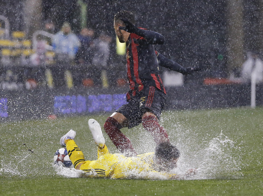 Third Place, Ron Kuntz Sports Photographer of the Year - Adam Cairns / The Columbus DispatchColumbus Crew forward Pedro Santos (7) falls to the wet ground after colliding with Atlanta United defender Leandro Gonzalez (5) during the first half of the MLS soccer match at MAPFRE Stadium in Columbus on March 30, 2019. 