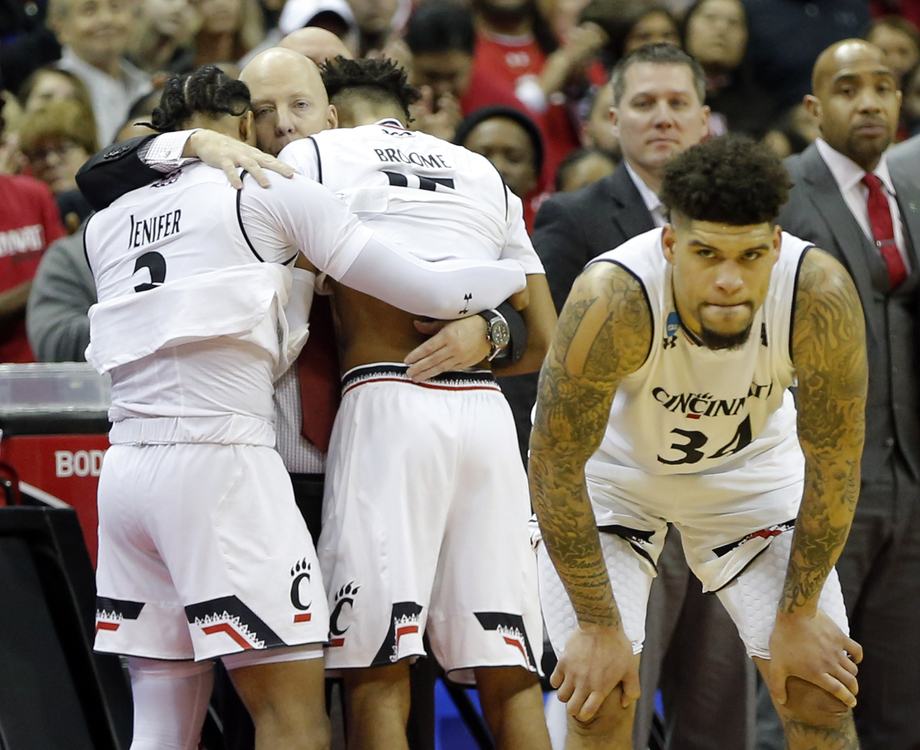 Third Place, Ron Kuntz Sports Photographer of the Year - Adam Cairns / The Columbus DispatchCincinnati Bearcats head coach Mick Cronin hugs guard Justin Jenifer (3) and guard Cane Broome (15) as guard Jarron Cumberland (34) waits for an inbounds pass in the final seconds of the NCAA men's basketball tournament first-round game against the Iowa Hawkeyes at Nationwide Arena in Columbus on March 22, 2019. Iowa won 79-72. 