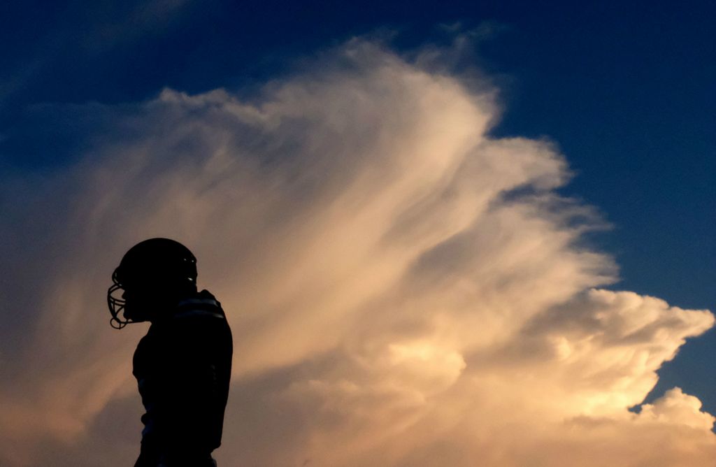 Award of Excellence, Ron Kuntz Sports Photographer of the Year - Kurt Steiss / The BladeA St. Francis football player stands in front as the sunset illuminates a billowing cloud during a high school football game between St. Francis de Sales and Anthony Wayne at the University of Toledo's Glass Bowl in Toledo on Friday, Sept. 13, 2019. 