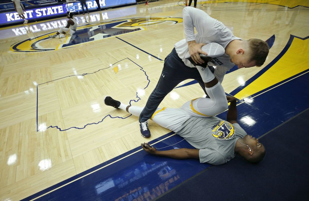 First Place, Sports Picture Story - Jeff Lange / Akron Beacon Journal, “Athlete With Autism”Basketball sports performance coach Brice Cox, top, helps Kalin Bennett get loose before Kent State's season opener against the Hiram College Terriers at the MAC Center, Wednesday, Nov. 6, 2019, in Kent, Ohio.