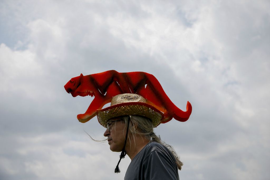 Second Place, Team Picture Story - Joshua A. Bickel / The Columbus Dispatch, “Tiger”Robert Drlicka, of Austin, Texas, wears a handmade Tiger Hat, an homage to Tiger Woods, while watching players on the driving range during a practice round of the Memorial Tournament on May 28, 2019 at Muirfield Village Golf Club in Dublin. Drlicka designed and hand cut the dies used to make the tiger for his hat, which took about two days to finish.