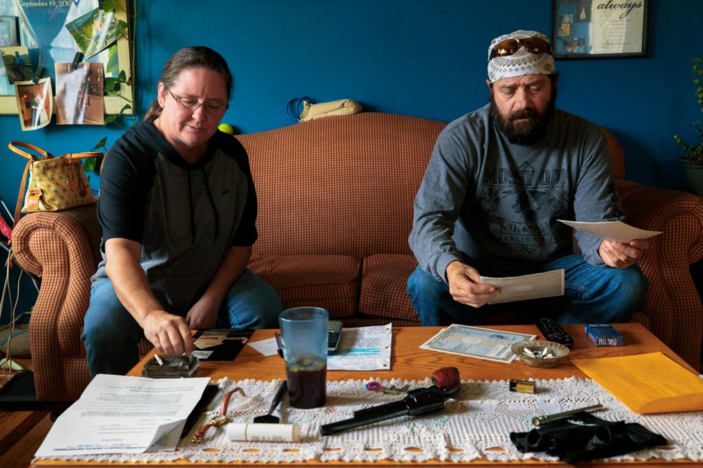 First Place, Chuck Scott Student Photographer of the Year - Carlin Stiehl / Ohio UniversityWendy Mitchel and Tom “Long Hair” Mitchell, examine documents needed to be notarized. The Mitchell’s keep a gun on their coffee table for protection from anyone breaking through the front door. The Mitchel family is one of the oldest and largest in Murray City. Tom jokes that he had to leave Murray to find his wife, “just to be safe.”