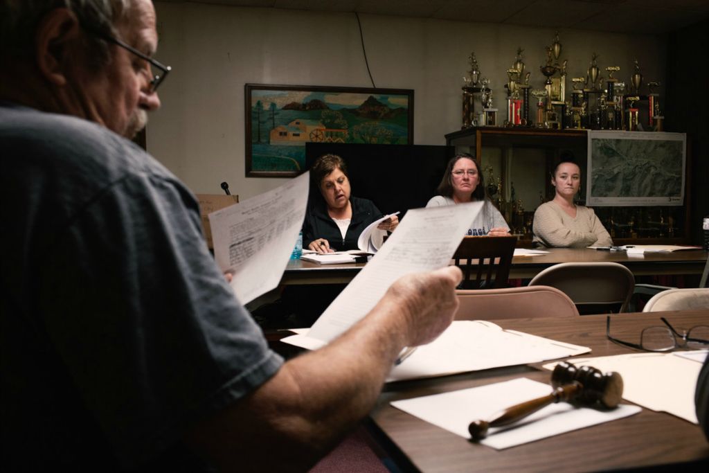 First Place, Chuck Scott Student Photographer of the Year - Carlin Stiehl / Ohio UniversityMayor Michael Dupler looks over documents with (left to right) Charma Berwanger, Wendy Mitchel, and Jessica Saunders regarding water usage within the village. Council meetings are where Murray’s established government decides on local laws and manages community grant projects such as the current sewer construction, which would prevent waste being directly dumped into the Snow Fork creek running through the village.  