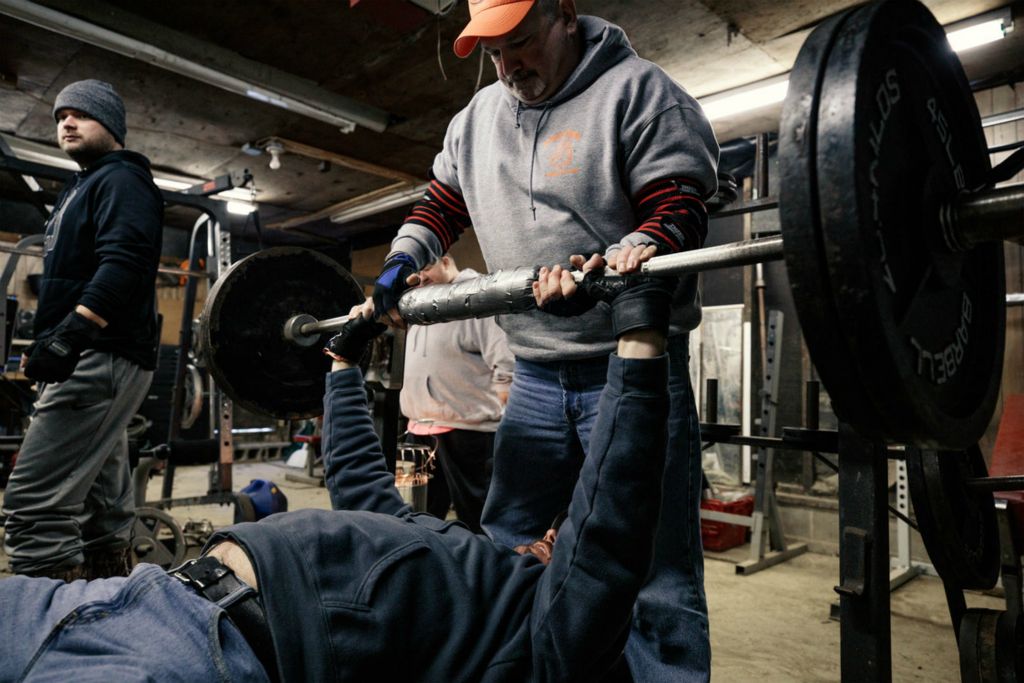 First Place, Chuck Scott Student Photographer of the Year - Carlin Stiehl / Ohio UniversityCraig Nungester spots the bench at The Power Shack, a gym he runs out of his garage in Murray City. The gym is open to anyone who needs a place to work out or relieve stress as long as they are clean and drug free. The Power Shack is known for its steroid free routine and has produced championship lifters.