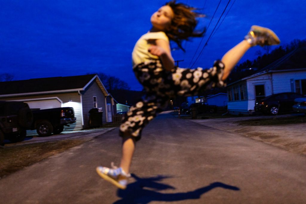 First Place, Chuck Scott Student Photographer of the Year - Carlin Stiehl / Ohio UniversityThe back streets of Murray City fall silent into the night as Emmalee Rutter practices her gymnastics in the middle of Hack Street. After school, kids ride their bikes, motorcycles and play at the park just doors down from their homes.