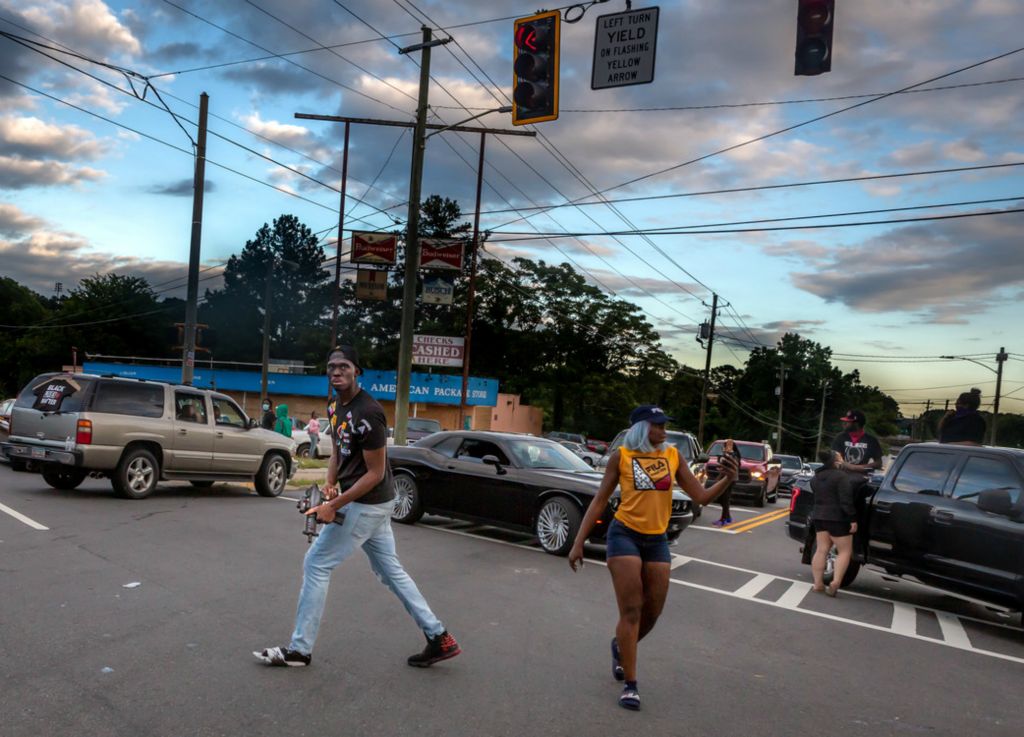 Second Place, Chuck Scott Student Photographer of the Year - Michael Blackshire / Ohio UniversityA protestor (center) paces with a uzi submachine gun as protestors use vehicles to block off a busy intersection in Atlanta, Ga on June 16, 2020. This followed within days of the shooting death of Rayshard Brooks outside of a Wendy’s by Atlanta police officer Garrett Rolfe. “I’m a clear the block. They not coming down here. I’m not going to kill my brother. I’m not going to hurt my sister. Cracker, I’m coming for your ass,” the gun-wielding protester said.
