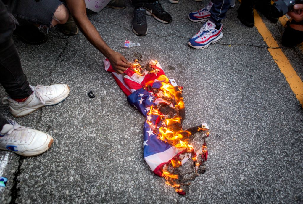 Second Place, Chuck Scott Student Photographer of the Year - Michael Blackshire / Ohio UniversityA protester lights his blunt as an American flag is burned on the ground in downtown Atlanta on June 2, 2020.