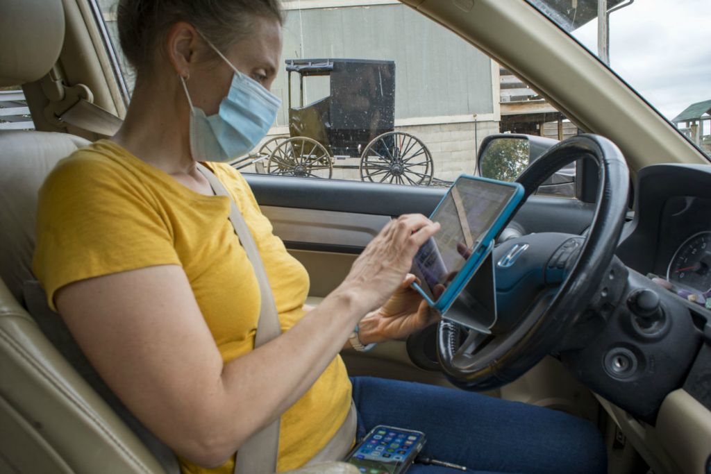 Third Place, Chuck Scott Student Photographer of the Year - Lauren Santucci / Ohio UniversityCertified Professional Midwife Lauren Genter checks her digital midwife records before an appointment with an Amish client in Hamden, Ohio on October 12, 2020. Lauren works with clients living within a sixty-mile radius of Athens, and about half of her clients are from the Amish communities in Vinton, Athens, and Morgan Counties.