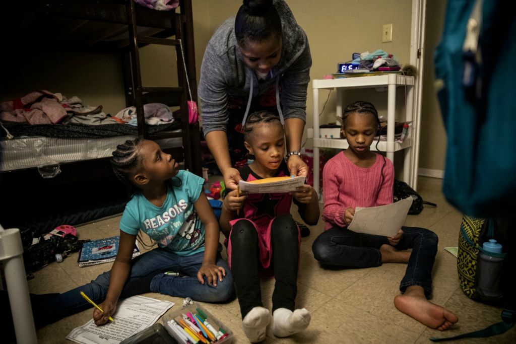 Award of Excellence, fps - Meg Vogel / The Cincinnati Enquirer, “Renters”Page Berry helps her three daughters Angelina, 7, Ajaunae, 8, and Amariyonna, 9, with their homework in the girls' bedroom in their basement apartment in Westwood on Tuesday, February 4, 2020.  About 88,000 Cincinnatians – almost 1 of 3 city residents – are in danger of losing the roofs over their heads every month. And every year, about 4,500 are forced out by eviction.