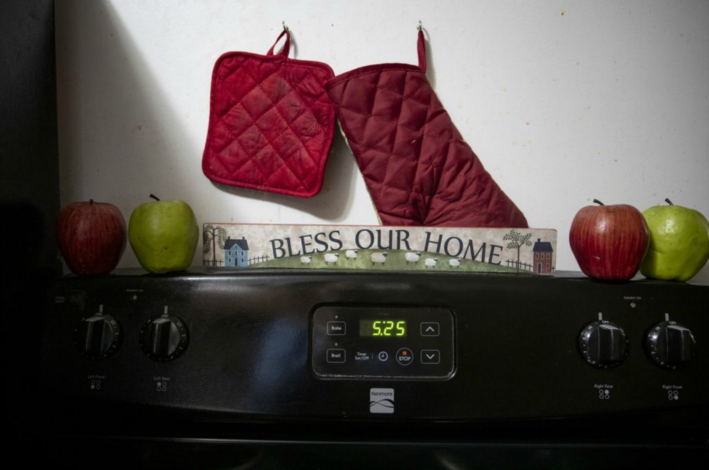 Award of Excellence, Feature Picture Story - Meg Vogel / The Cincinnati Enquirer, “Renters”A "Bless Our Home" sign decorates the top of the stove in Page Berry's home in Westwood on Tuesday, February 4, 2020. Page takes a lot of pride in decorating her apartment. She wants the basement apartment to feel like home for her daughters. 