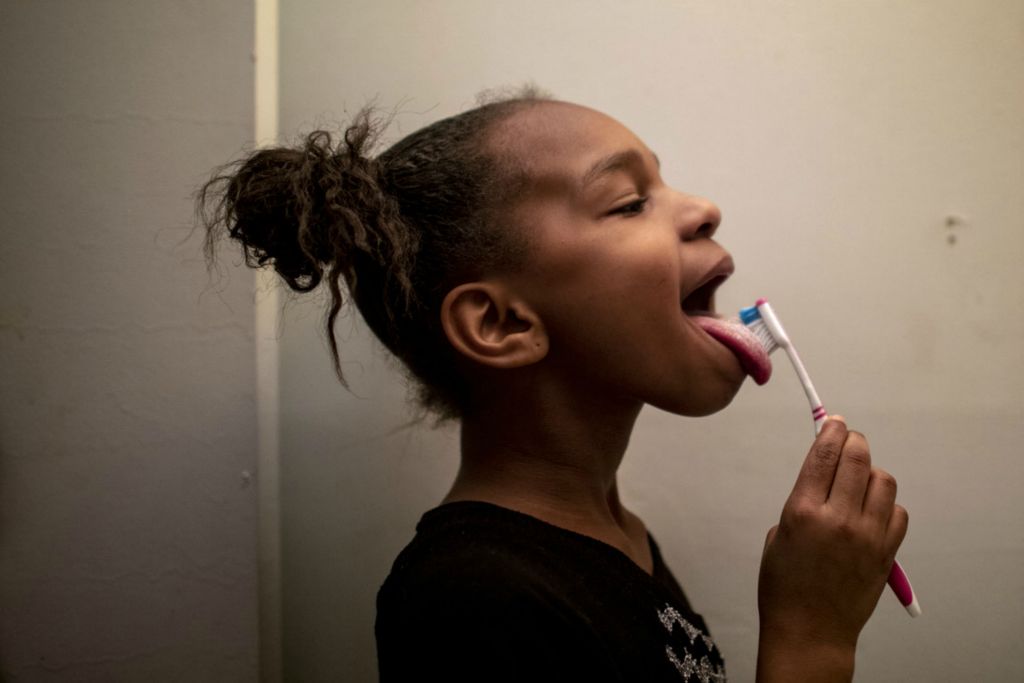 Award of Excellence, Feature Picture Story - Meg Vogel / The Cincinnati Enquirer, “Renters”Amariyonna, 9, brushes her teeth in the bathroom with her sisters on Wednesday, February 26, 2020. “This is not where I want to be,” Page Berry told herself before signing the lease in January 2019. “This is where I got to be.” The apartment building’s security door didn’t lock and the light in the hallway didn’t work. The kitchen sink leaked and the ceiling over the shower was in the early stages of collapse.