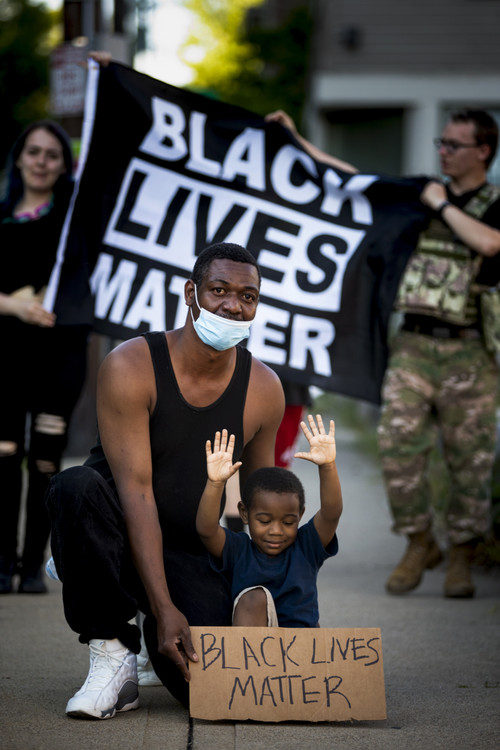 Award of Excellence, News Picture Story - Meg Vogel / The Cincinnati Enquirer, “BLM Protest”Willie Coman kneels with his son, Willie Jr., 4, on Sunday, May 31, 2020, during the protests in Cincinnati in response to George Floyd's death in Minneapolis. He said, "The police are killing us, and we have babies." Willie was proud to bring his son to see the large crowds protesting against police brutality. "He is the next generation. When I say 'Hands up,' my son immediately replies, 'Don't shoot.' That's what he knows." Willie and his family left before the tear gas dispersed the crowd.